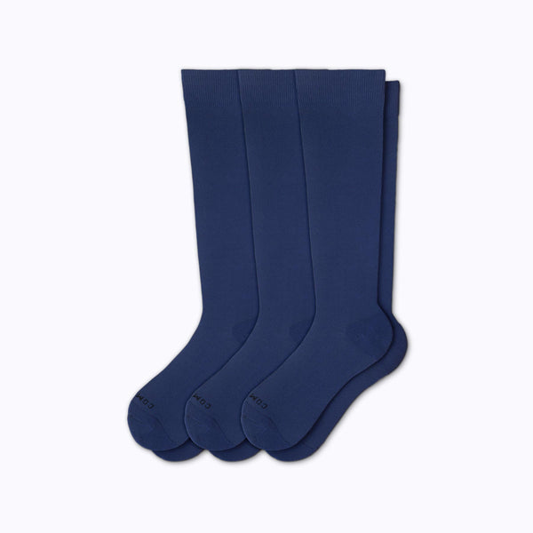 Three pairs of navy knee-high socks on a white background