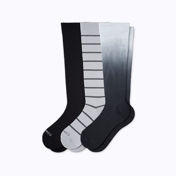Three pairs of knee-high socks in black, gray, and white with striped patterns on a white background.