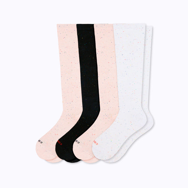 Set of four knee-high socks in rose, white, and black on a white background