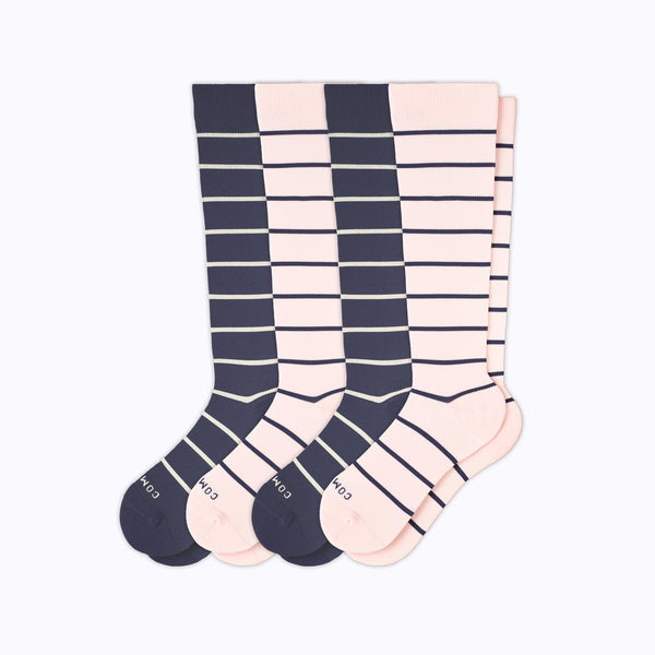 Four pairs of knee-high socks with a vertical stripe pattern in navy blue and pale pink, displayed on a clean white background.