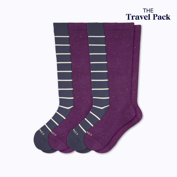 Two pairs of knee-high socks with colors navy sand stripes and potent purple on a white background, labeled 'The Travel Pack'.