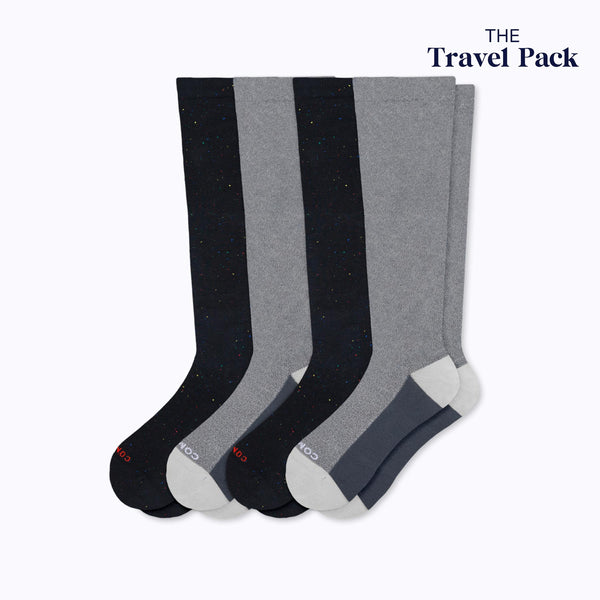 4 pack of knee high compression socks, 2 black recycled cotton and 2 grey cloudcotton. Upper right-hand badge says The Travel Pack