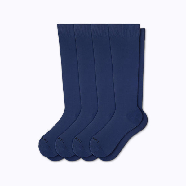 Set of four navy socks on a light gray background