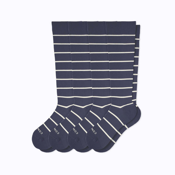 Set of four navy blue socks with white stripes on a white background