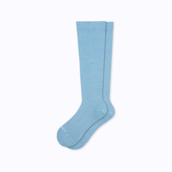 Pair of flat nee-high light blue cotton compression socks on a white