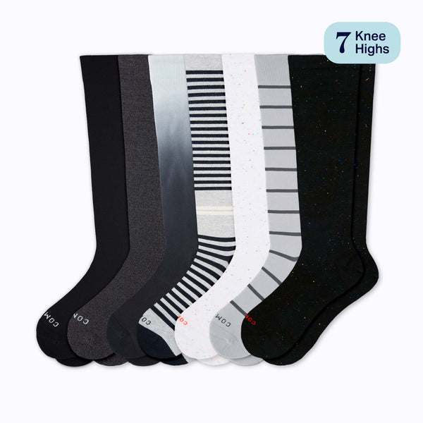 Set of seven pairs of knee-high socks in black, gray, and white with striped patterns on a white background.