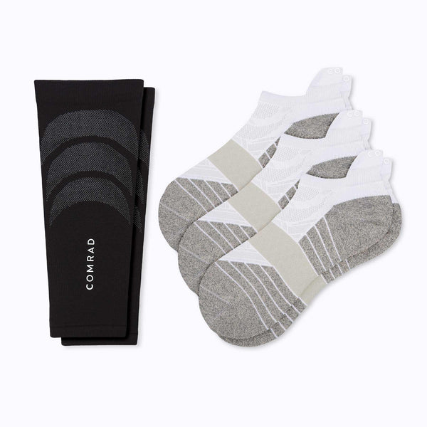 Black sock with geometric pattern and white socks with gray and beige pattern on a white background