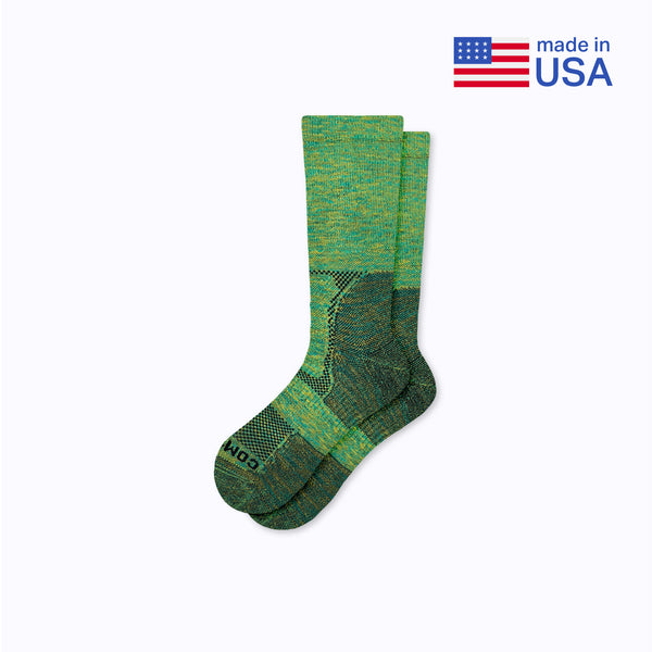 Green socks with a pattern on a white background, featuring 'made in USA' text and an American flag.