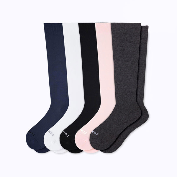 Set of five pairs of knee-high socks in navy, white, black, pink, and gray on a white background.
