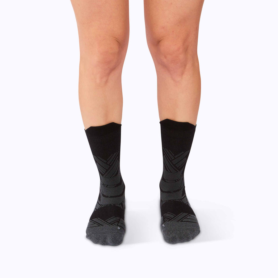 Front view of a pair of legs wearing an athletic crew compression socks black solid