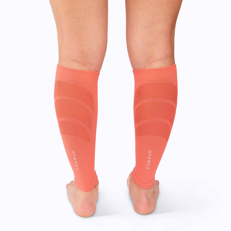 Back view of feet wearing a calf compression sleeve performance blend coral solid