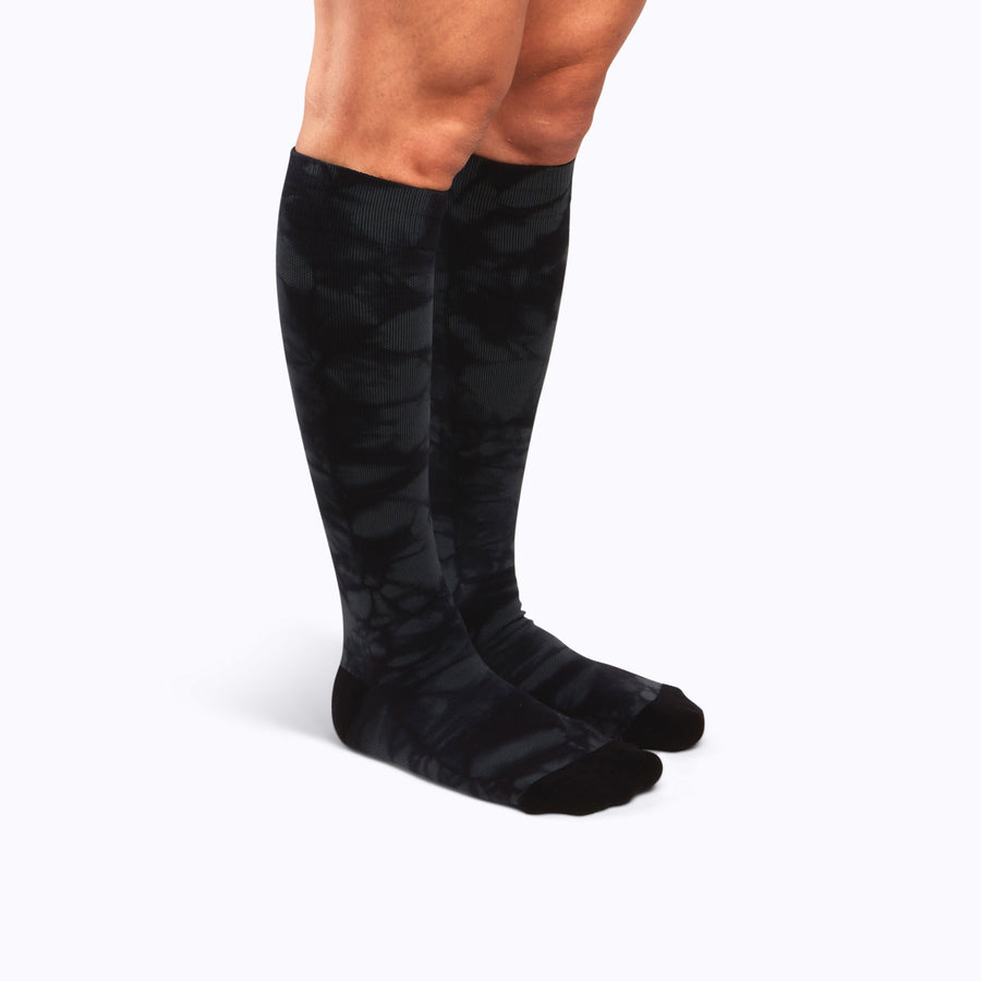 Side view of legs wearing a nylon knee high compression socks in black twist-dye