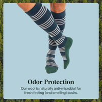 Knee-high socks with white stripes worn by a person, set against a light blue background with greenery.