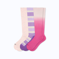 Three pairs of knee-high socks with recycled rose, lavender with mulberry stripes and berry ombre on a white background