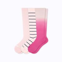 Set of three knee-high socks with gradient pink and striped design on a white background