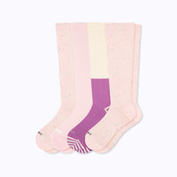 Set of three knee-high socks in pastel colors on a white background