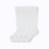 Set of four white socks on a light gray background