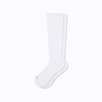 A pair of white knee-high compression socks made from recycled cotton, displayed against a plain background.