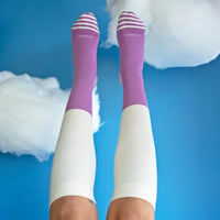 Purple and white knee-high socks with 'COMBRA' branding on a blue background.