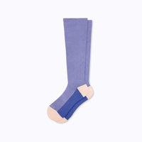 Flat product image of a pair of purple knee-high socks with rose colored heel and tow on a light grey background