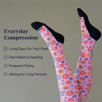 Colorful floral compression socks with text on a gray background