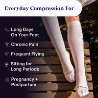Compression socks being worn with a list of benefits on a wooden surface