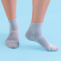 Gray socks worn by a person on a light blue background