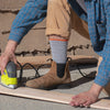 A construction worker wearing Comrad Sock's crew-length work socks with compression