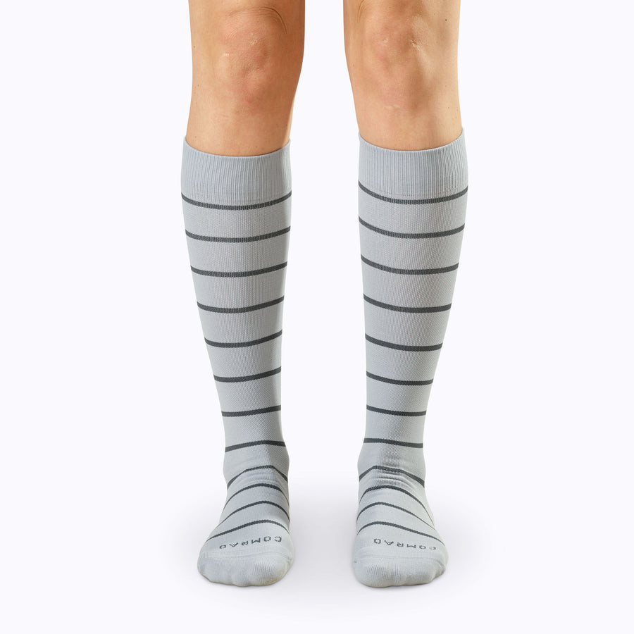 Front view of legs wearing a pair of knee high compression socks in grey-charcoal stripes