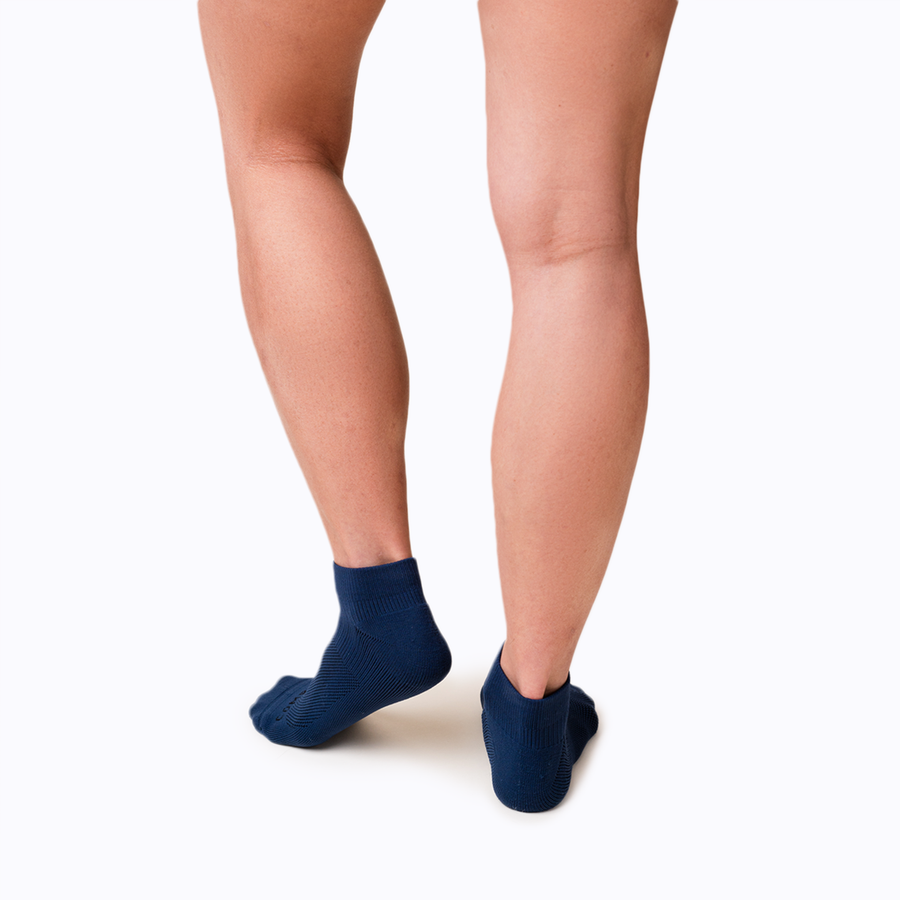 Back view of feet wearing nylon ankle compression socks in navy solid