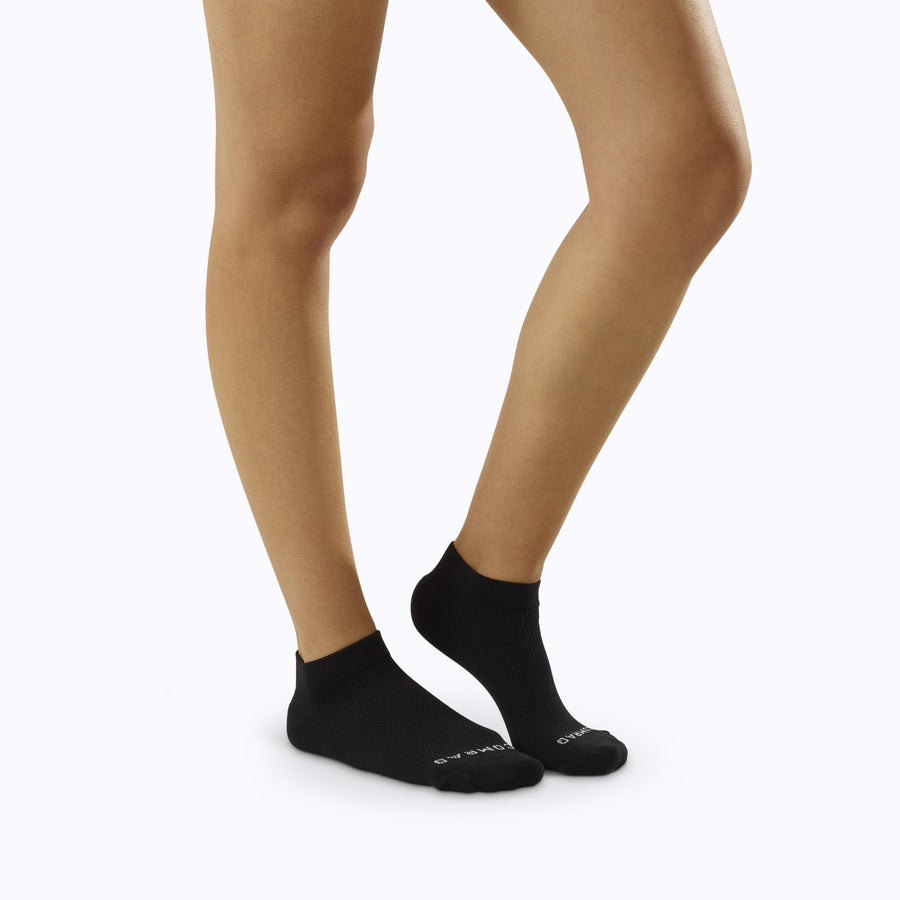Side view of feet wearing nylon ankle socks in black solid
