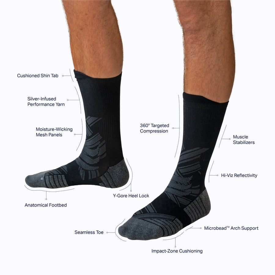 Side view of a pair of legs wearing an athletic crew compression socks black tech solid