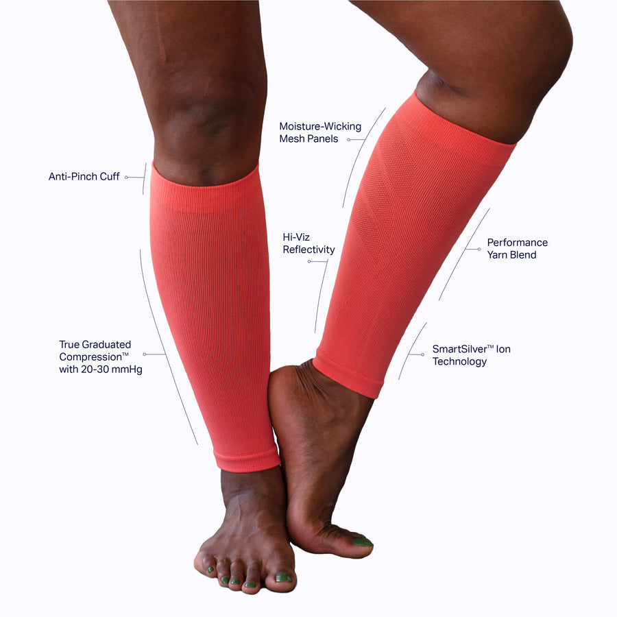 A pair of feet wearing a calf compression sleeve performance blend tech coral solid