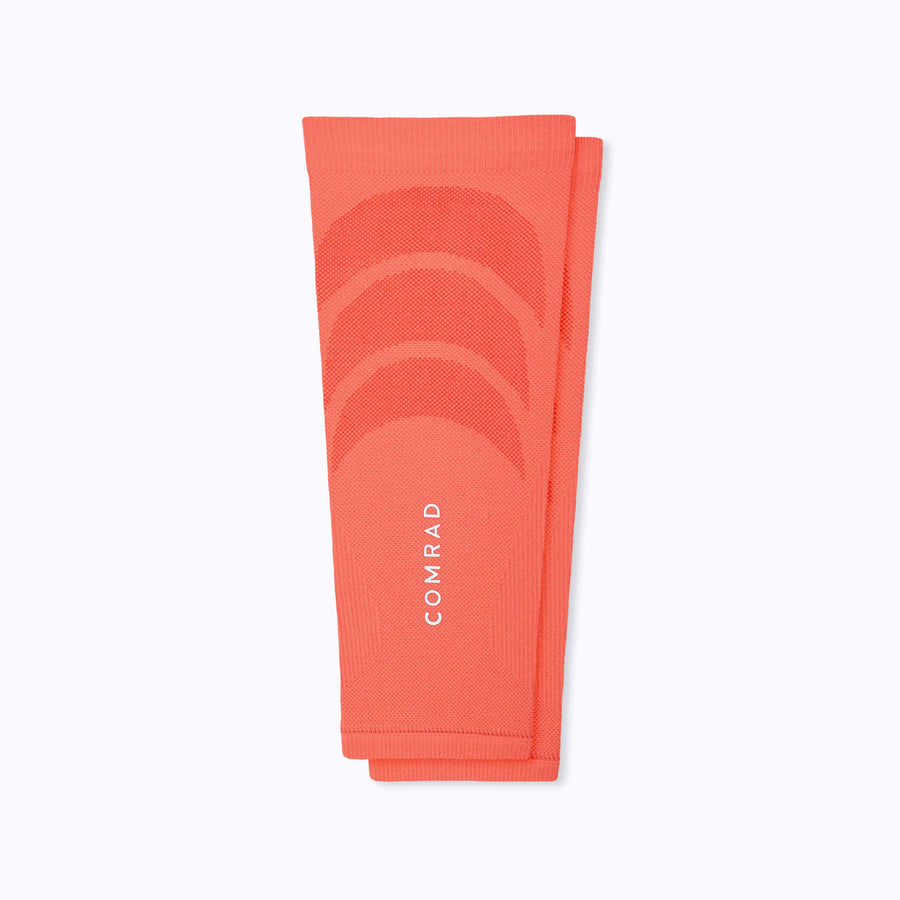 A pair of calf compression sleeve performance blend coral solid