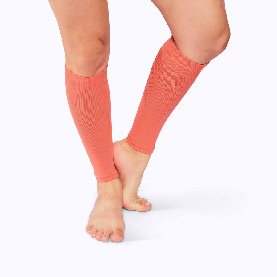 Front view of feet wearing a calf compression sleeve performance blend coral solid