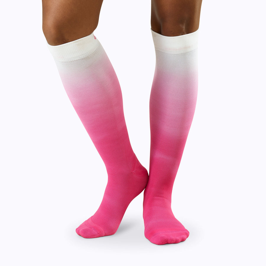 Front view of a pair of legs wearing nylon knee high compression socks in berry ombre