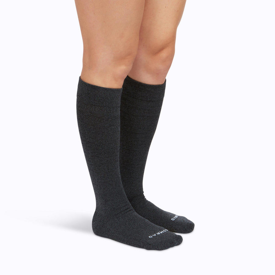 Side view of a pair of legs wearing nylon knee high compression socks in heather-charcoal solid